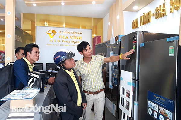 Anh Bùi Đức Vĩnh đang giới thiệu sản phẩm cho khách hàng tại một trung tâm thuộc hệ thống Điện máy Gia Vĩnh. Ảnh:V.Thế