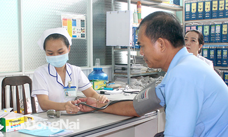 Nhân viên y tế kiểm tra huyết áp cho người cao tuổi tại Trung tâm y tế huyện Nhơn Trạch