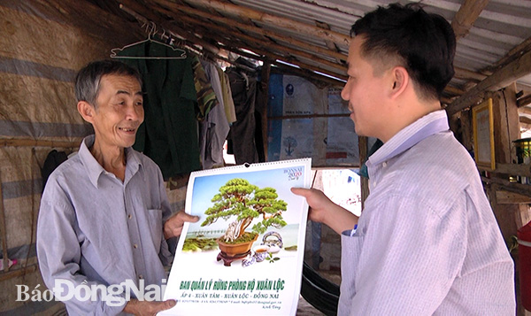 Cán bộ lãnh đạo Ban Quản lý rừng phòng hộ Xuân Lộc thăm, tặng lịch cho các hộ dân sinh sống trong đất lâm phận. Ảnh: H.Đình
