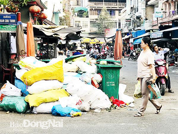 Công nhân vệ sinh môi trường vừa thu gom rác xong, chợ Biên Hòa lại đầy rác. Ảnh: P.Liễu