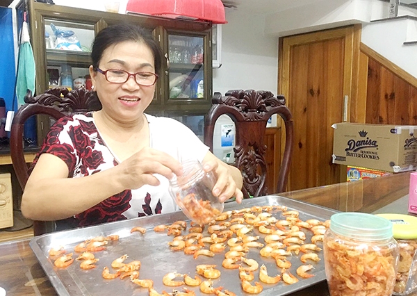 Bà Trần Thị Tuyết (ngụ KP.5, P.Tân Hiệp, TP.Biên Hòa) cho tôm khô vào hũ để bảo quản trong ngăn mát tủ lạnh. Ảnh: Nga Sơn
