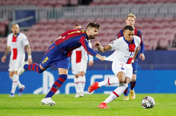 Kylian Mbappe bị Gerard Pique kéo áo trong trận PSG thắng Barcelona 4-1. Ảnh: Reuters
