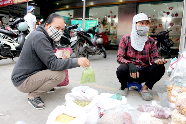 Bà Bùi Thị Tuyết (quê tỉnh Thanh Hóa) bán đặc sản cốm dẻo Hà Nội ở lề đường tại TP.Biên Hòa. Ảnh: B.Mai