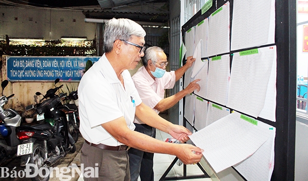 Cử tri KP.3, P.Trung Dũng, TP.Biên Hòa đang kiểm tra danh sách cử tri được niêm yết tại Nhà văn hóa khu phố mình
