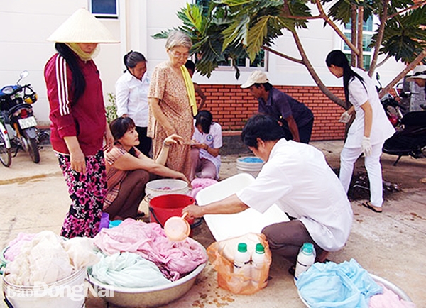 Nhân viên y tế tẩm mùng hóa chất cho người dân xã Nam Cát Tiên, H.Tân Phú. Ảnh: TT