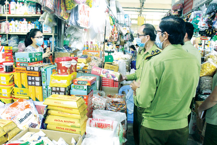 Lực lượng quản lý thị trường tỉnh khảo sát, kiểm tra các sạp hàng thực phẩm khô, tạp hóa tại chợ Long Thành trong đợt cao điểm khảo sát, kiểm tra thị trường hàng hóa đầu năm 2021 Ảnh: LAM PHƯƠNG