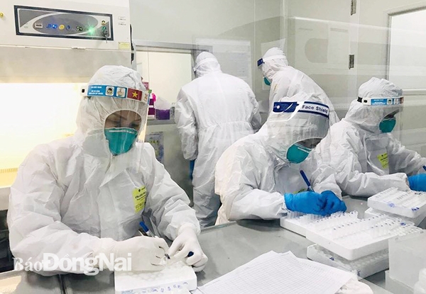  Nhân viên y tế Bệnh viện Đa khoa khu vực Long Khánh mặc đồ bảo hộ đầy đủ để lấy mẫu xét nghiệm test nhanh SARS-CoV-2.