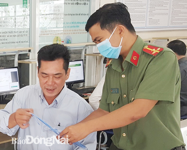 Cán bộ Phòng Cảnh sát quản lý xuất nhập cảnh Công an tỉnh hướng dẫn người dân làm thủ tục.