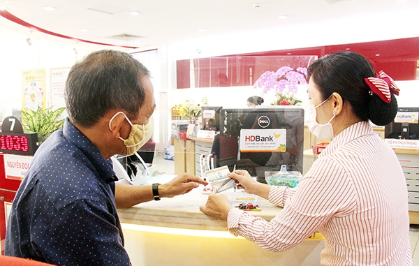 Nhân viên HDBank chi nhánh sở giao dịch Đồng Nai tư vấn cho khách hàng những tiện ích, điểm khác nhau giữa thẻ chip và thẻ từ truyền thống. Ảnh: Hải Quân
