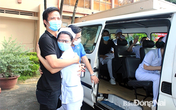 Nữ điều dưỡng Bệnh viện Nhi đồng Đồng Nai ôm chia tay chồng để vào làm nhiệm vụ tại Bệnh viện Dã chiến số 4. Ảnh: H.Dung