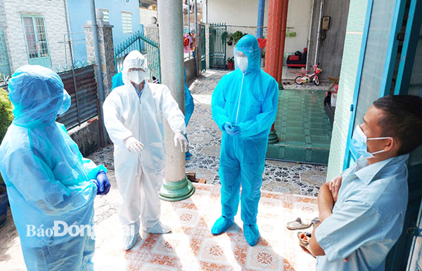 Nhân viên y tế hướng dẫn F1 cách ly tại nhà ở P.Hố Nai, TP.Biên Hòa. Ảnh: H.Dung