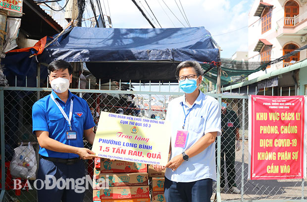 Đại diện Cụm thi đua số 3 Công đoàn viên chức tỉnh Đồng Nai trao tặng 1,5 tấn rau, củ, quả cho người dân trong vùng bị phong tỏa tại phường Long Bình (Ảnh: Huy Anh)