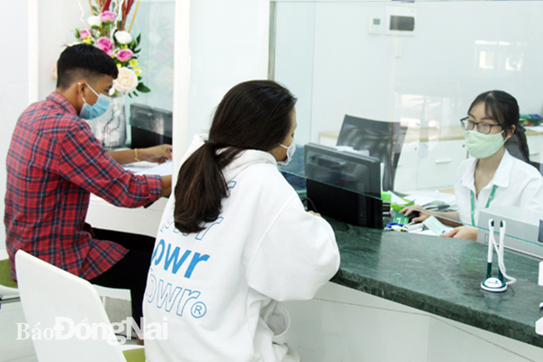 Nhiều ngân hàng thương mại trong tỉnh đang triển khai các chương trình hỗ trợ tín dụng dành cho các khách hàng, doanh nghiệp chịu ảnh hưởng bởi dịch Covid-19. Trong ảnh: Khách hàng đến giao dịch tại một ngân hàng thương mại ở TP.Biên Hòa