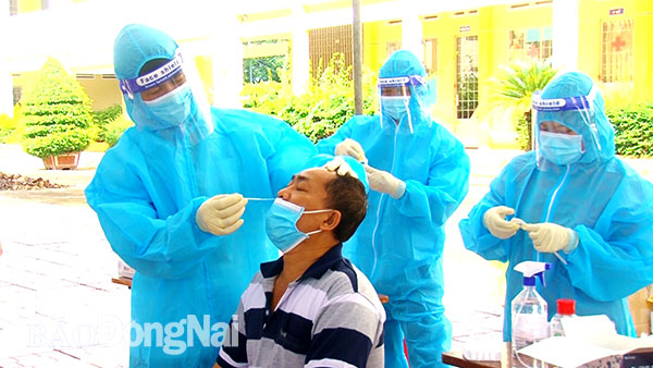 Nhân viên y tế lấy mẫu xét nghiệm nhanh cho người dân ở H.Xuân Lộc. Ảnh: Hoàng Lộc