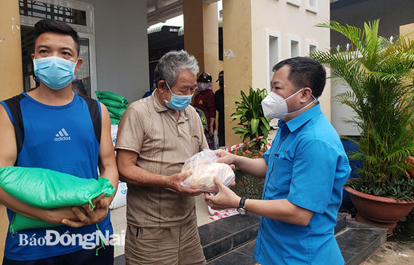 Phó chủ tịch LĐLĐ tỉnh Tăng Quốc Lập trao túi an sinh cho người dân tại xã Vĩnh Tân, H.Vĩnh Cửu. Ảnh: Lan Mai