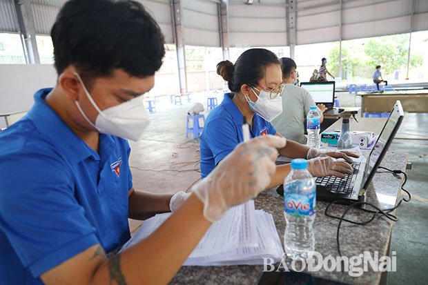 Đoàn viên Đoàn phường Trung Dũng nhập thông tin tờ khai của người dân được tiêm ngừa vaccine vào máy tính. Ảnh: H.Anh
