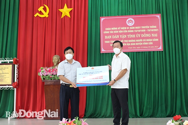 Trưởng Ban Dân vận Tỉnh ủy Đào Văn Phước trao bảng biểu trưng 300 phần quà cho người dân khó khăn trên địa bàn huyện Vĩnh Cửu