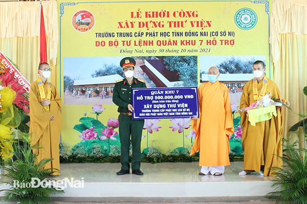 Đại tá Nguyễn Công Anh trao bảng tượng trưng 500 triệu đồng hỗ trợ xây dựng công trình. Ảnh: Nguyệt Hà