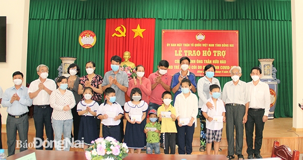 Chủ tịch Ủy ban MTTQ Việt Nam tỉnh Cao Văn Quang cùng ông Trần Hữu Hào trao quà cho các em mồ côi cha mẹ do dịch Covid-19.