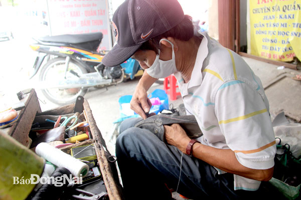 Bên cạnh những tiệm may quần áo, trên đường Quang Trung cũng có một số tiệm sửa giày dép. Trong ảnh: Ông Trần Văn Phát, một thợ sửa giày dép cũng đã có mặt tại tuyến phố này được 25 năm. Ảnh: Trần Danh