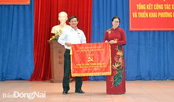 Bí thư Đảng ủy Khối DN tỉnh Lê Thị Ngọc Loan tặng cờ thi đua của Ban TVTU cho tổ chức Đảng trực thuộc khối đạt trong sạch vững mạnh tiêu biểu 5 năm liền 2016-2020