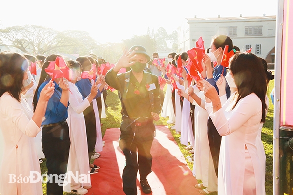 Thanh niên Long Khánh vẫy tay chào lãnh đạo và người thân trước khi xe lăn bánh về đơn vị mới