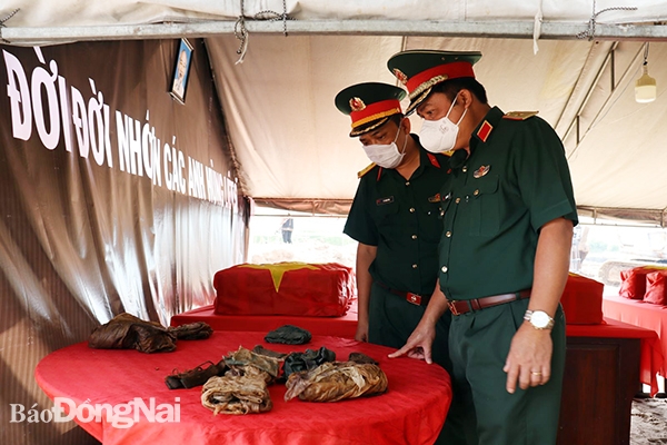 Phó chính ủy Quân khu (phải) thăm các di vật còn lại của liệt sĩ