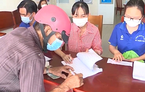 Người lao động nhận hỗ trợ tiền thuê trọ tại xã Thạnh Phú (H.Vĩnh Cửu). Ảnh: N.Hòa