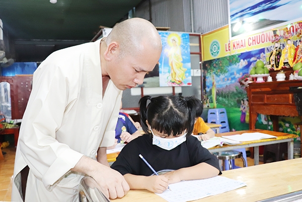 Đại đức Thích An Thuận tận tình dạy cho các em nhỏ tập viết
