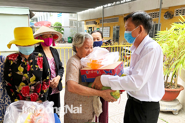 Ông Lý Nàm Sáng (người uy tín dân tộc Hoa) trao quà cho bà con có hoàn cảnh khó khăn tại P.Tân Phong, T.Biên Hòa. Ảnh: Ly Na