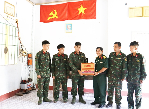 Đại tá Nguyễn Minh Cảnh, Chính ủy Trường Bắn quốc gia khu vực 3 tặng quà cho cán bộ, chiến sĩ chốt Cô Kiều - một trong những chốt khó khăn còn phải chạy ắc-quy để có điện thắp sáng
