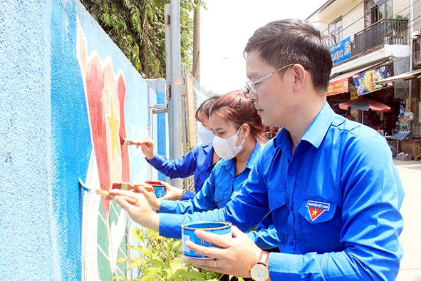 Bí thư Đoàn xã Phú Sơn (H.Tân Phú) cùng với đoàn viên thanh niên sơn lại tranh tường trên tuyến đường thanh niên tự quản