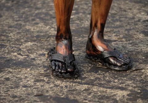 Đôi chân một công nhân bị dính dầu thô bị tràn ở một tỉnh Liêu Ninh phía đông bắc của Trung Quốc.  