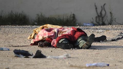 Một chiến binh chết trên đường phố Tripoli được phủ một tấm chăn. Giao tranh dữ dội đang diễn ra gần Dinh thự của ông Gaddafi. (Ảnh: Getty)