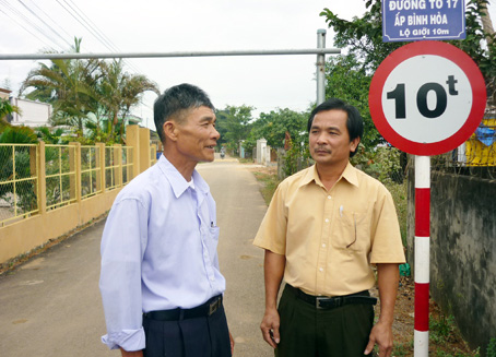 Ông Nguyễn Đức Thứ (trưởng ấp Bình Hòa, xã Xuân Phú, phải) và trưởng ban công tác Mặt trận ấp giới thiệu đoạn đường tổ 17 vừa bê-tông hóa. Ảnh: Diễm Quỳnh