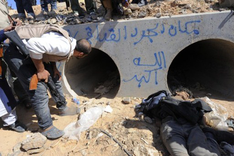 Binh sĩ NTC phát hiện đường ống bê tông, nơi ông Gadhafi được tìm thấy. Ngay bên cạnh đó là xác của một người thuộc phe trung thành với nhà lãnh đạo bị lật đổ.