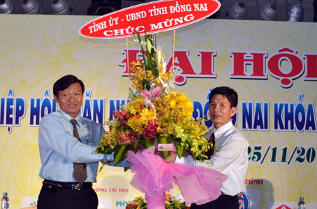 Ông Nguyễn Trí Công (trái) Chủ tịch Hiệp hội chăn nuôi Đồng Nai  nhận hoa chúc mừng của Tỉnh ủy, UBND tỉnh.