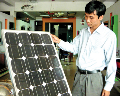 Anh Bùi Văn Nam bên tấm bảng pin mặt trời, sản phẩm mà anh kỳ vọng nhiều trong tương lai.