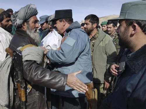  Một cựu phần tử Taliban (trái) bắt tay quan chức cảnh sát Afghanistan tại một buổi lễ ở Baghlan, phía Bắc Kabul. Ảnh: AP 