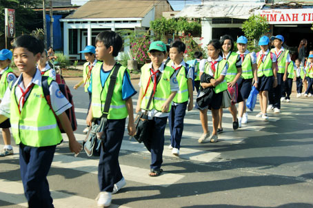 Học sinh qua đường trên vạch kẻ đường mới hoàn tất. Ảnh: N. Tuyết