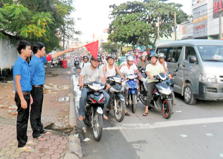 Các thành viên trong đội thanh niên tình nguyện đang làm nhiệm vụ tại nút giao thông trên đường Võ Thị Sáu, TP.Biên Hòa. Ảnh:  V.TRUYÊN