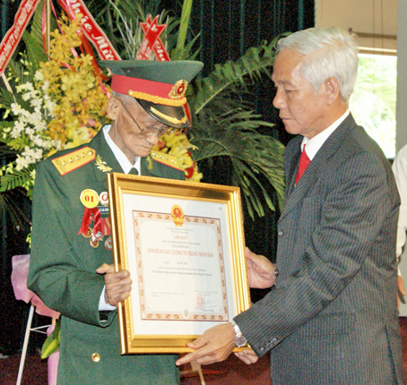 Phó bí thư thường trực Tỉnh ủy Lê Hồng Phương trao danh hiệu Anh hùng lực lượng vũ trang nhân dân cho Đại tá Lê Bá Ước.  Ảnh: N. Sơn