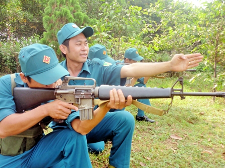 Anh Trần Lương Thành đang hướng dẫn dân quân thường trực bắn súng bộ binh AR16.