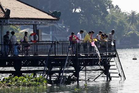 Nhiều người đến thả cá trong Nhà Mát trên sông Đồng Nai.      Ảnh: VĨNH HUY