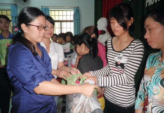 Các thành viên trong đoàn trao quà cho trẻ em khuyết tật, nạn nhân chất độc da cam tại huyện Long Thành.