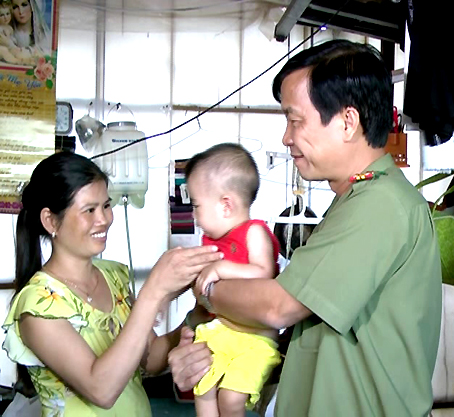Đại tá Lý Quang Dũng, Trưởng công an huyện Trảng Bom, trao trả em bé cho gia đình.