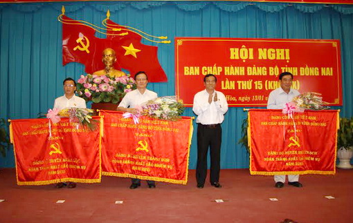 Đồng chí Trần Đình Thành trao cờ thi đua xuất sắc năm 2013 cho 3 đơn vị Xuân Lộc, Trảng Bom và Nhơn Trạch.