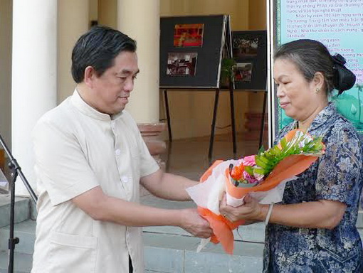 đồng chí Huỳnh Văn Tới tặng hoa cho bà Huỳnh Thị Thành (con gái út của Thi tướng Huỳnh Văn Nghệ) tại lễ khai mạc triển lãm ảnh