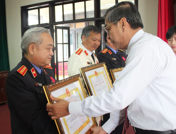 Chủ tịch HĐND tỉnh Trần Văn Tư gắn Huân chương lao động hạng 3 cho các cá nhân đạt thành tích.