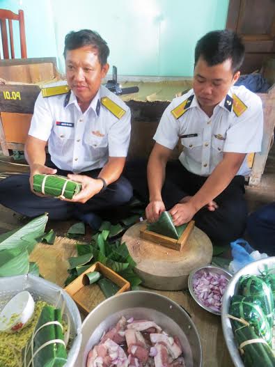 Thiếu tá Nguyễn Văn Đoàn, Chỉ huy trưởng nhà giàn DK1/10 (bên trái) gói bánh chưng đón Tết.